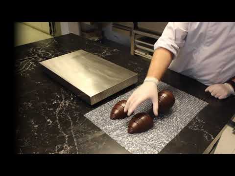 YouTube video tutorial demonstrating how to create and decorate chocolate Easter eggs using professional chocolate molds and techniques